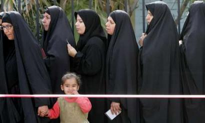Iraqi women queue at a school polling station in the At Maeel area of Basra, southern Iraq, January 30, 2005. REUTERS/Toby Melville