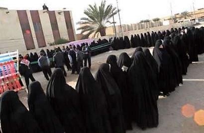 Iraqi Shi'ite women line up to participate in their country's national elections, outside a polling station in the holy city of Najaf, January 30, 2005.Photo by Stringer/Iraq/Reuters